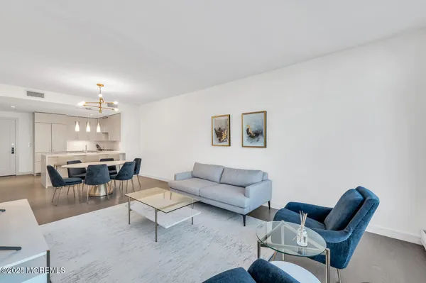 a living room with furniture a rug and a dining table