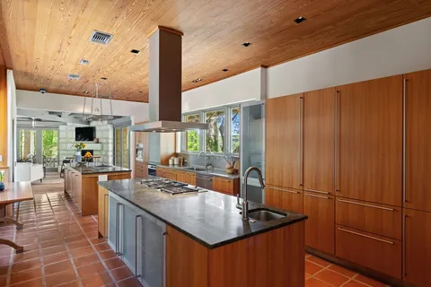 a kitchen with granite countertop a sink appliances and cabinets