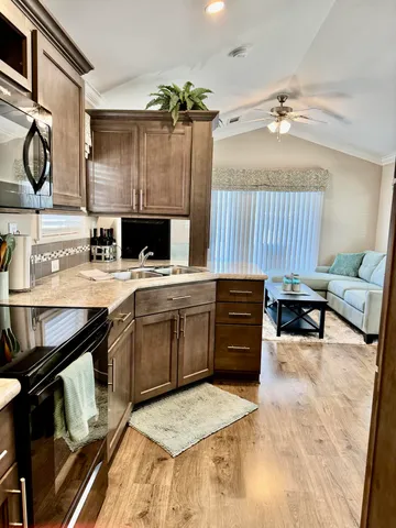 a kitchen with stainless steel appliances granite countertop a refrigerator a stove and a sink