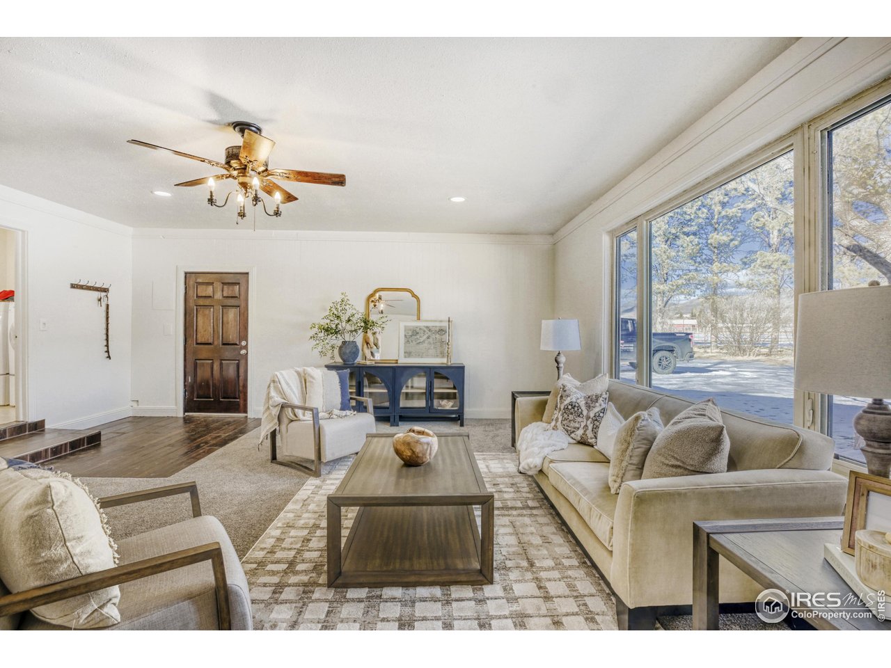 6921 Ridge Valley Court Loveland, CO 80538 - Photo 14 of 50 a living room with furniture a chandelier and a large window