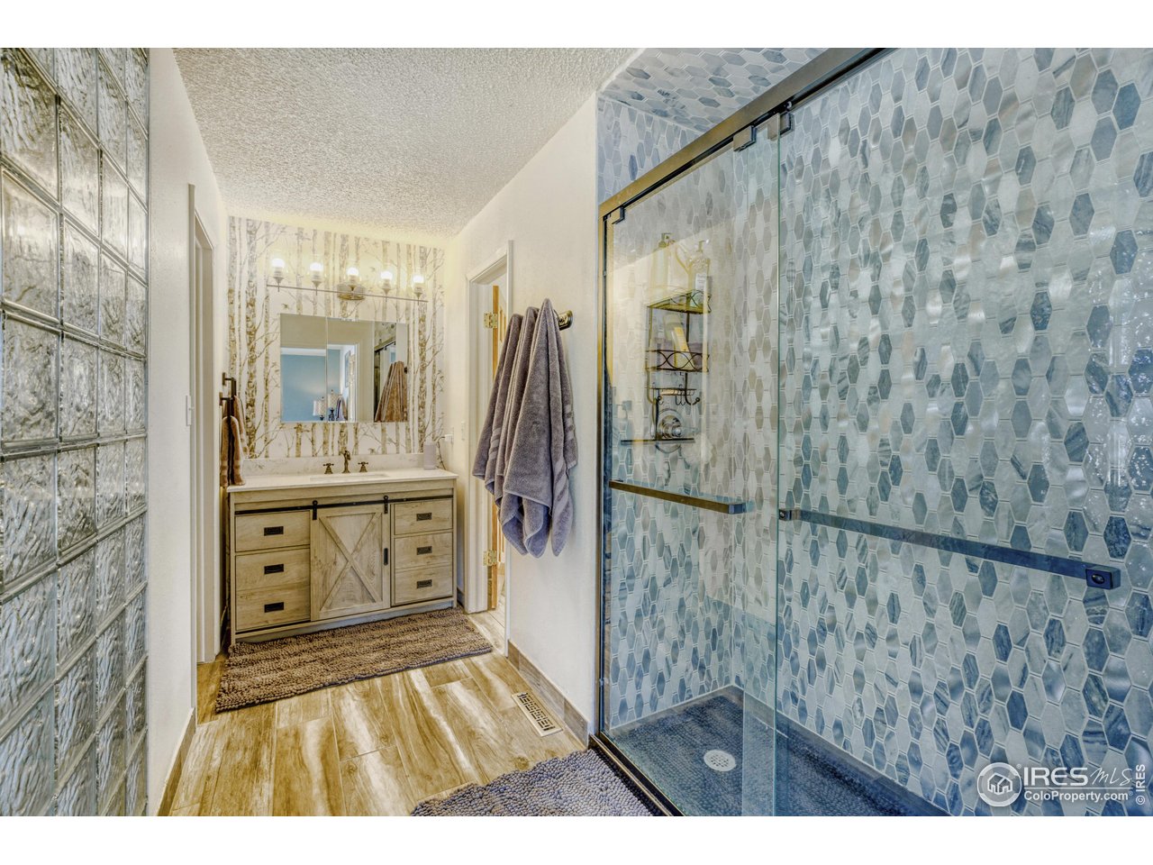 6921 Ridge Valley Court Loveland, CO 80538 - Photo 21 of 50 a bathroom with a sink a mirror and a shower