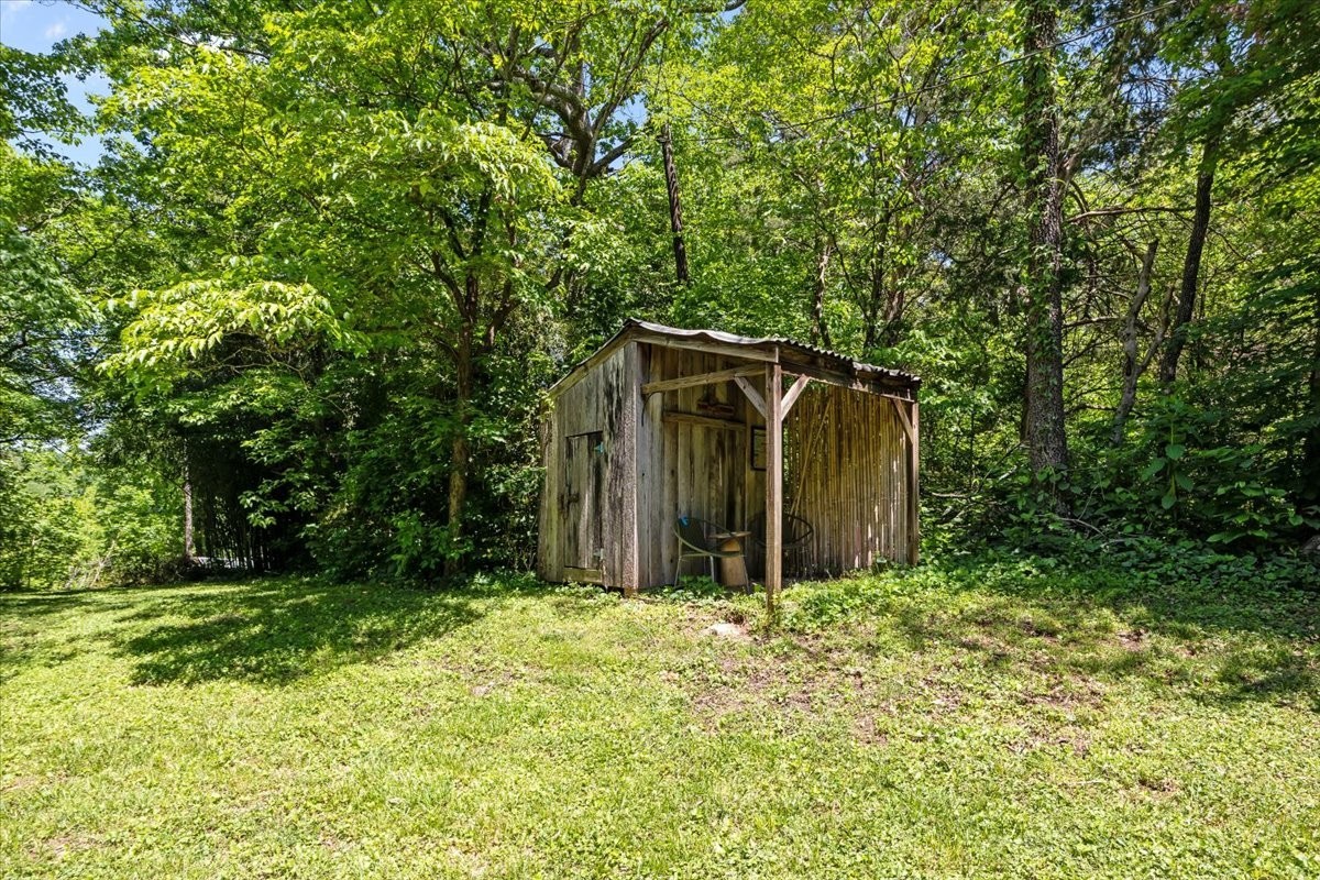 2440 Maple Grove Road Dickson, TN 37055 - Photo 65 of 99 a backyard of a house with large trees and plants