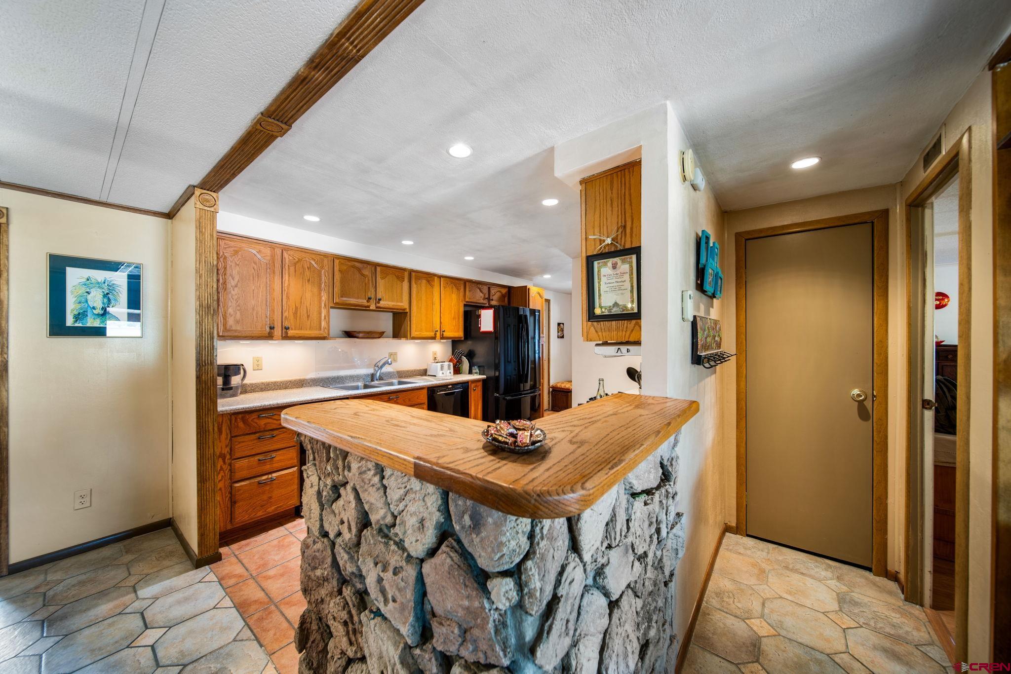 7853 County Road 334 Ignacio, CO 81137 - Photo 23 of 39 a kitchen with stainless steel appliances kitchen island granite countertop a table chairs and a refrigerator