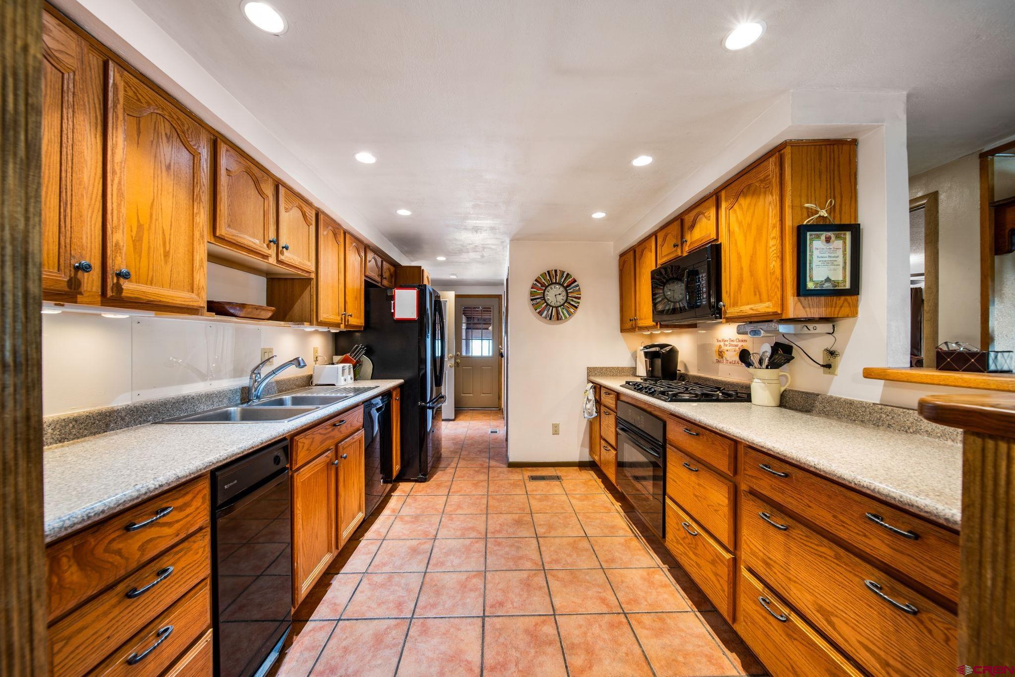 7853 County Road 334 Ignacio, CO 81137 - Photo 8 of 39 a large kitchen with stainless steel appliances granite countertop a large stove top oven a sink dishwasher and cabinets with wooden floor
