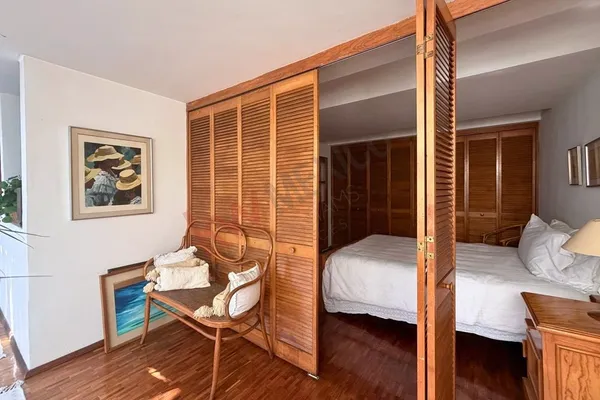 a large bed sitting in a bedroom next to a window