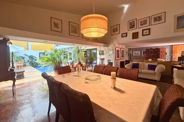a view of a dining room with furniture a chandelier and large windows
