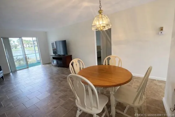 a dining room with furniture a chandelier and wooden floor