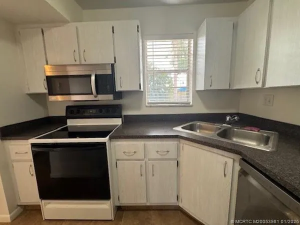 a kitchen with a sink stove and microwave