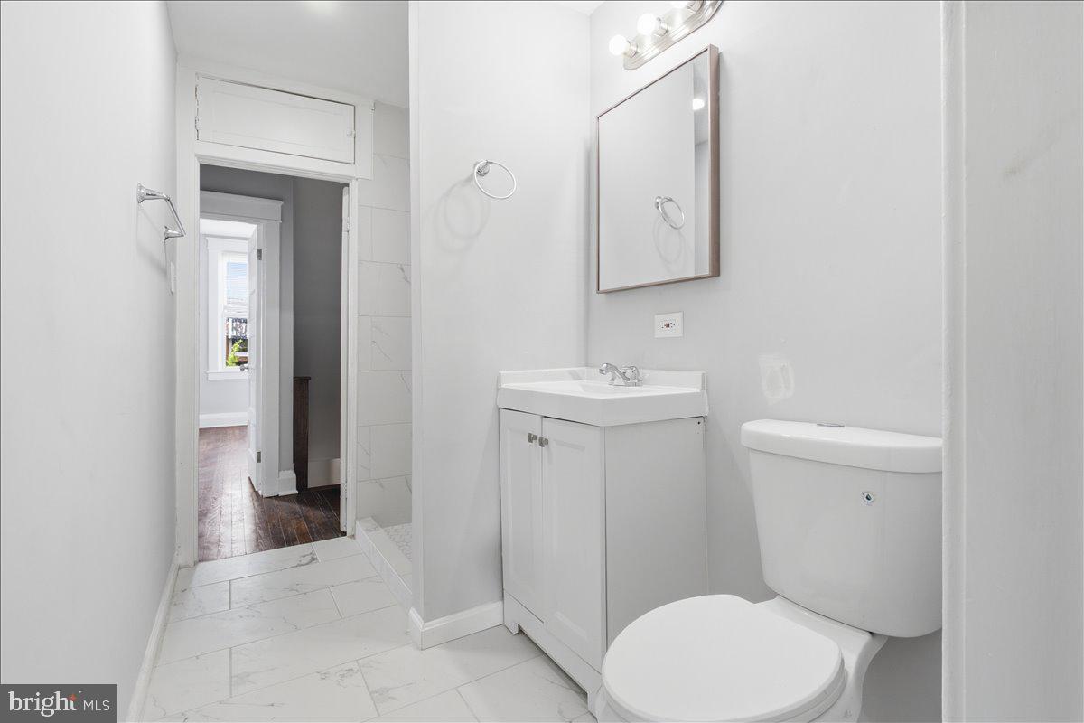 1231 North Potomac Street Baltimore, MD 21213 - Photo 18 of 25 a bathroom with a toilet sink and mirror