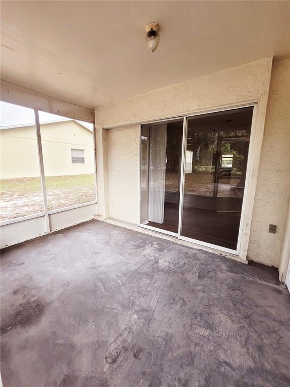 4331 Azora Road Spring Hill, FL 34608 - Photo 15 of 16 an empty room with sliding glass door and glass door