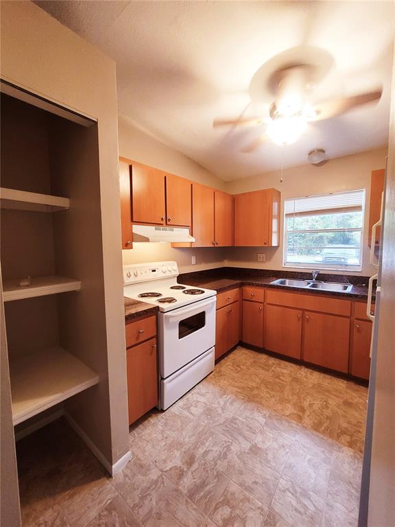 4331 Azora Road Spring Hill, FL 34608 - Photo 7 of 16 a kitchen with granite countertop a stove a sink and a microwave