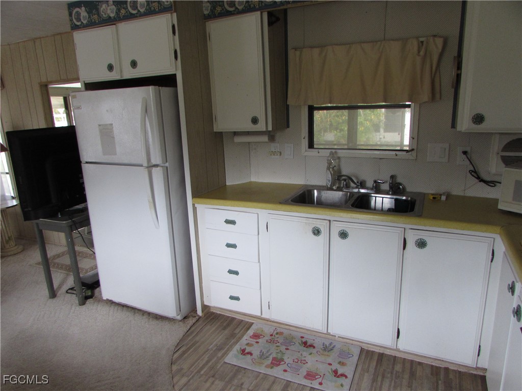 7711 Farrell Road Bokeelia, FL 33922 - Photo 21 of 21 a kitchen with granite countertop white cabinets and refrigerator
