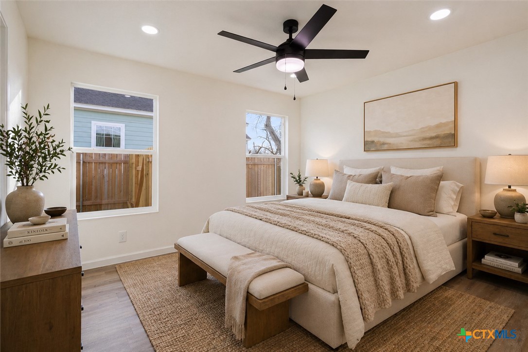 707 South 13th Street Temple, TX 76504 - Photo 13 of 24 a spacious bedroom with a bed and a chandelier