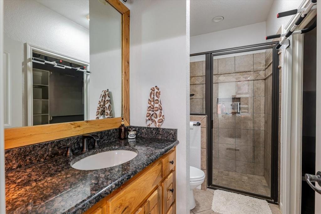 318 East Lone Star Road Poolville, TX 76487 - Photo 28 of 33 a bathroom with a granite countertop sink and a mirror