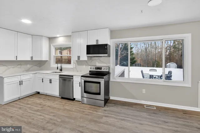 a kitchen with a stove a sink and a microwave