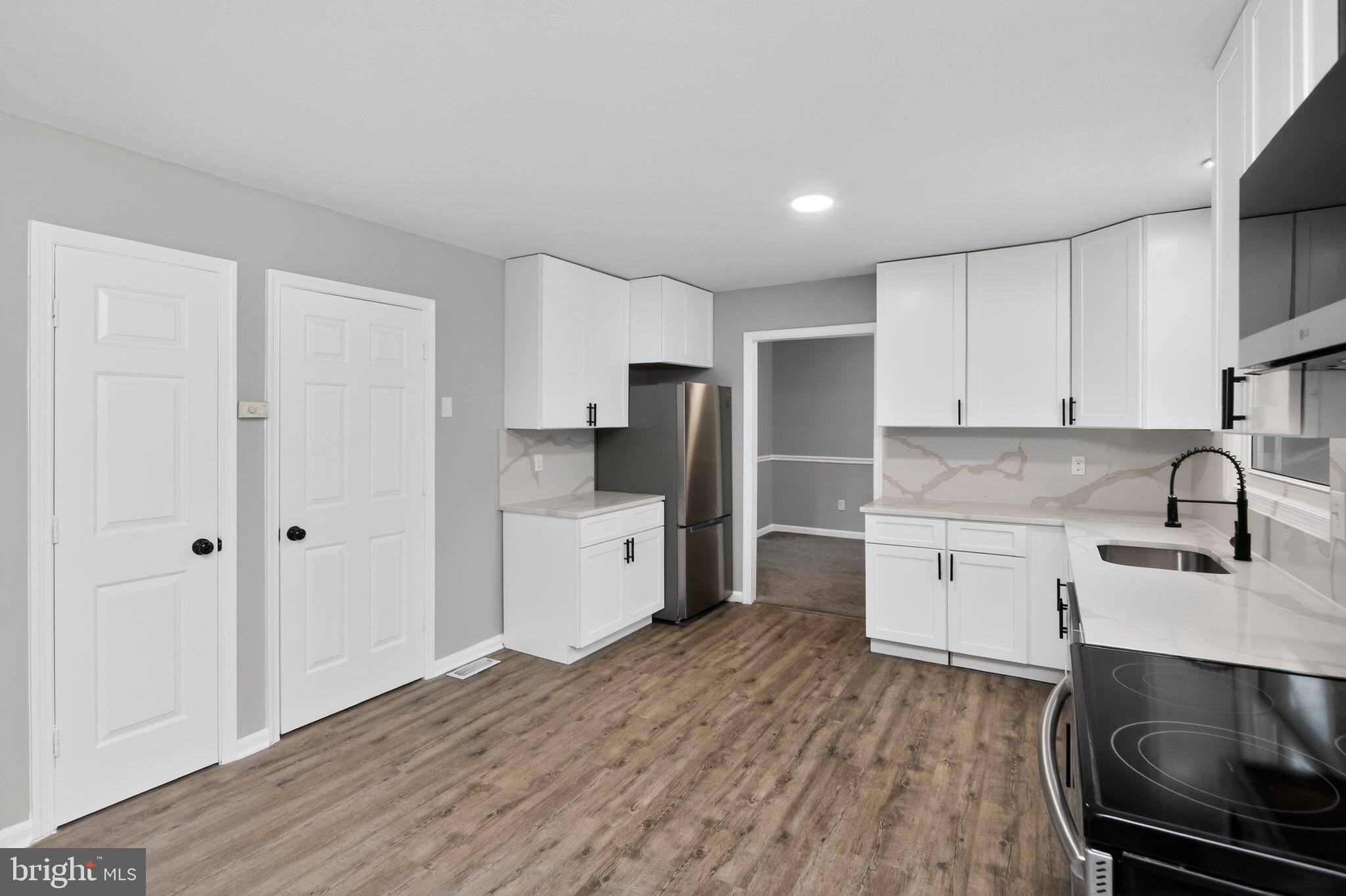 11979 Falling Creek Drive Manassas, VA 20112 - Photo 21 of 30 a kitchen with stainless steel appliances a stove sink and cabinets