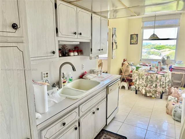 a kitchen with stainless steel appliances a sink a stove and white cabinets next to a window