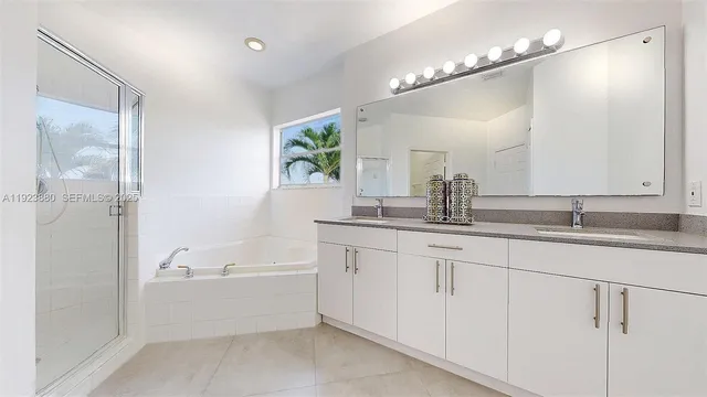 a bathroom with a double vanity sink a mirror and a bathtub