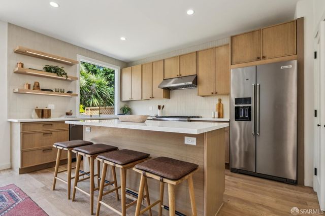 a kitchen with stainless steel appliances a sink a stove and a window