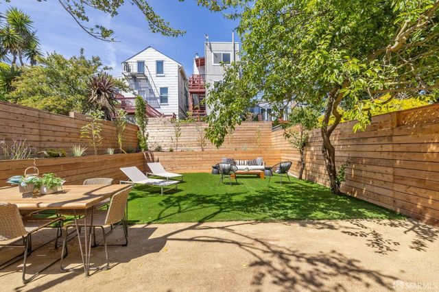 a backyard of a house with table and chairs