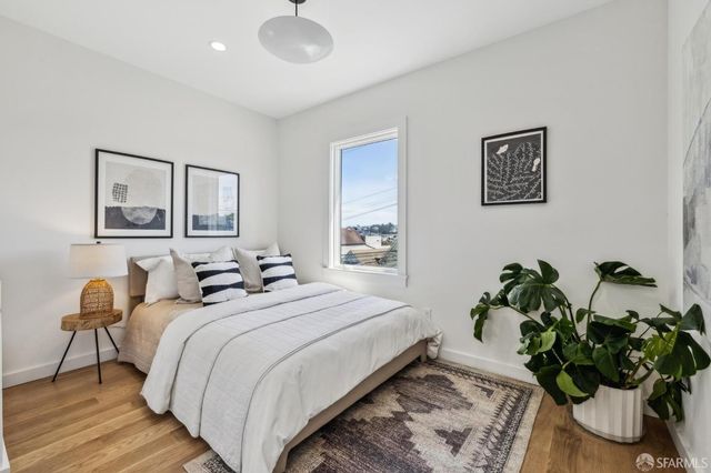 a bedroom with a bed and a painting on the wall