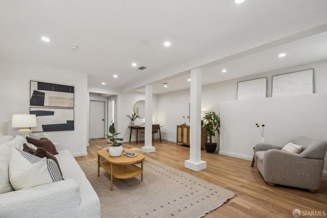 a spacious bedroom with a bed and wooden floor