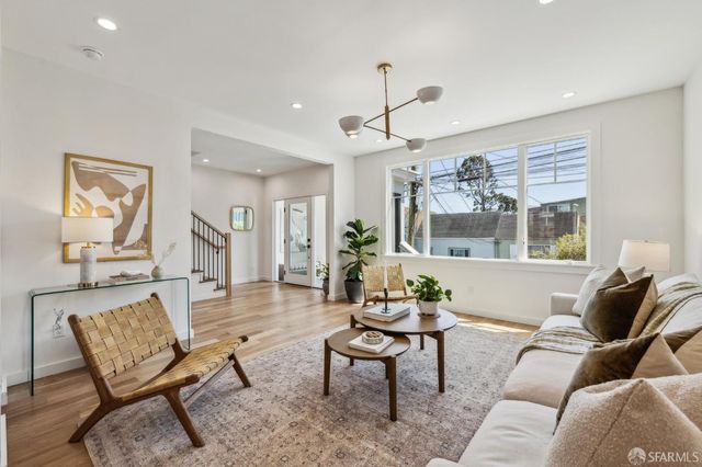 a living room with furniture potted plant a rug and a window