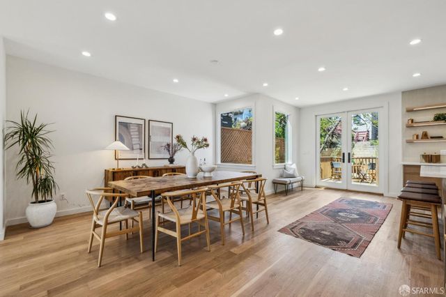 a large kitchen with kitchen island a stove a sink a dining table and chairs