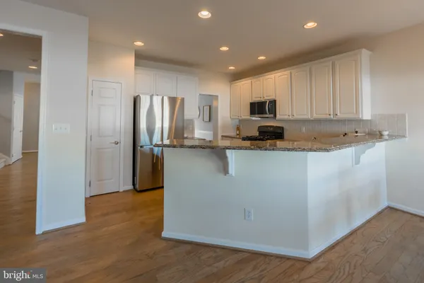 a kitchen with stainless steel appliances granite countertop a refrigerator sink and microwave