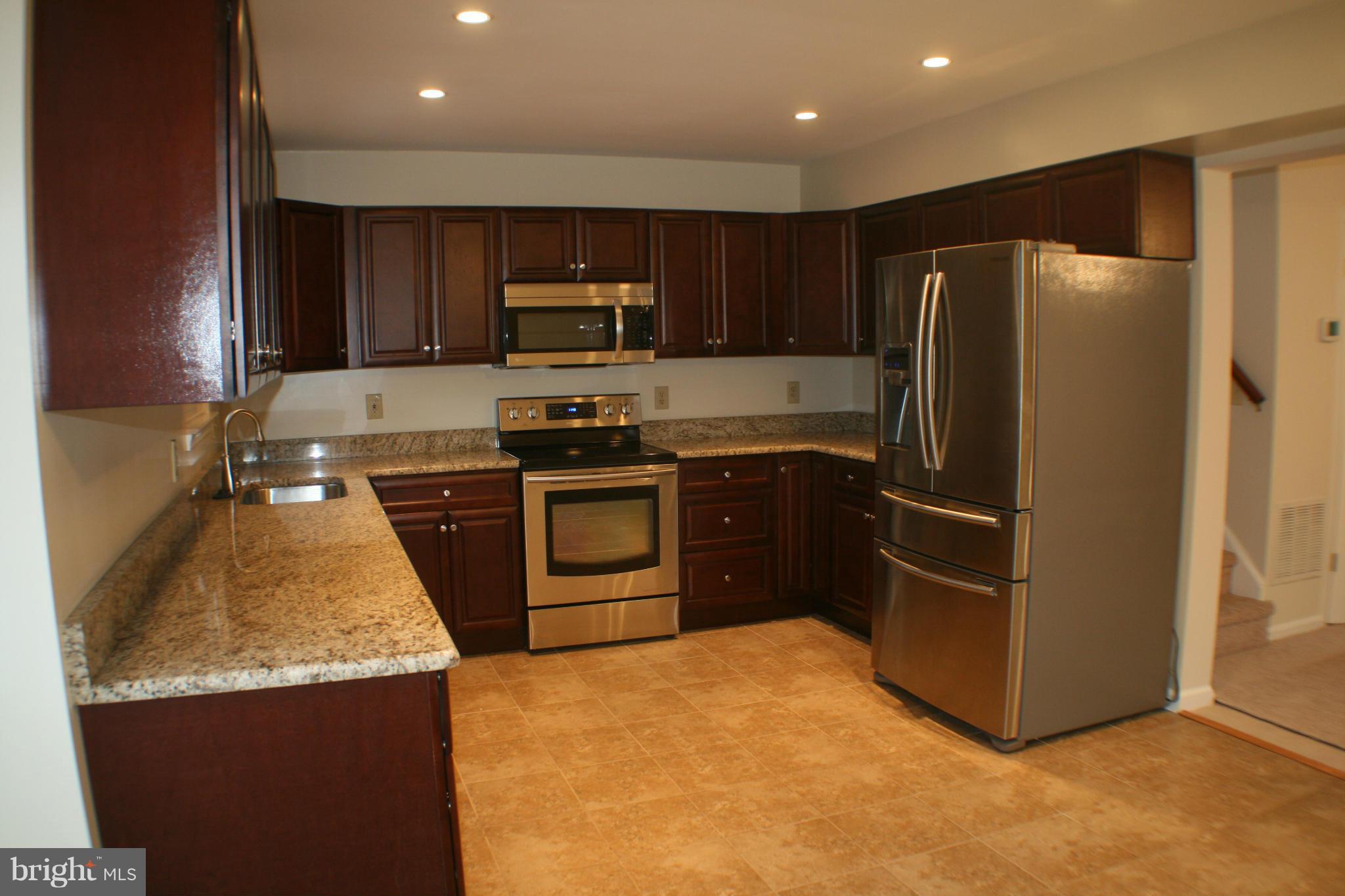 13930 Baton Rouge Court Centreville, VA 20121 - Photo 26 of 26 a kitchen with stainless steel appliances granite countertop a refrigerator a stove a sink and a microwave