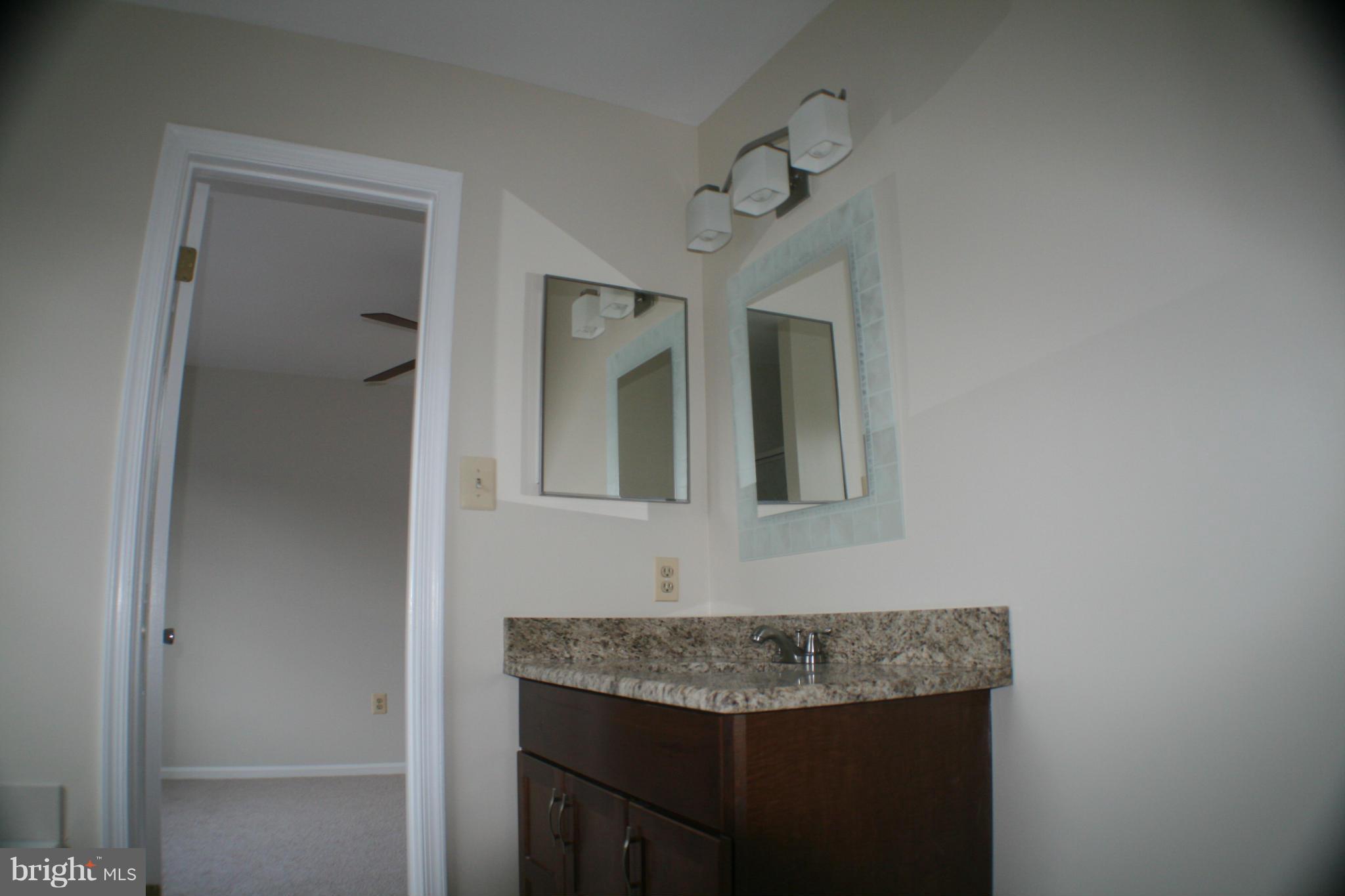 13930 Baton Rouge Court Centreville, VA 20121 - Photo 4 of 26 a bathroom with a granite countertop sink and a mirror