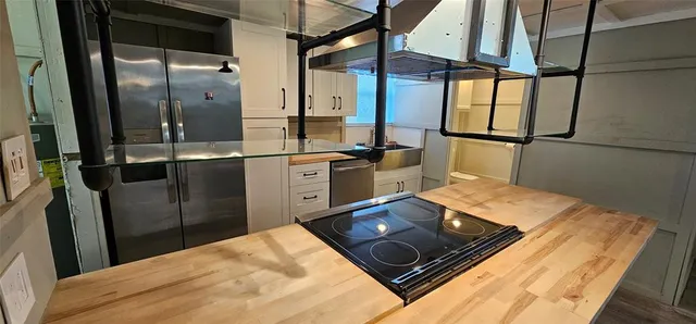 a kitchen with stainless steel appliances granite countertop a refrigerator and a stove