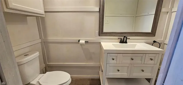 a bathroom with a sink a toilet and a mirror