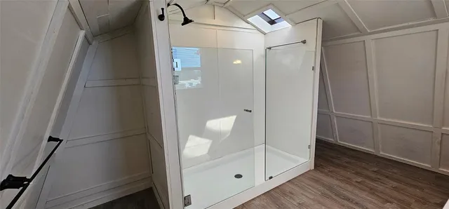 a bathroom with a glass shower door and sink