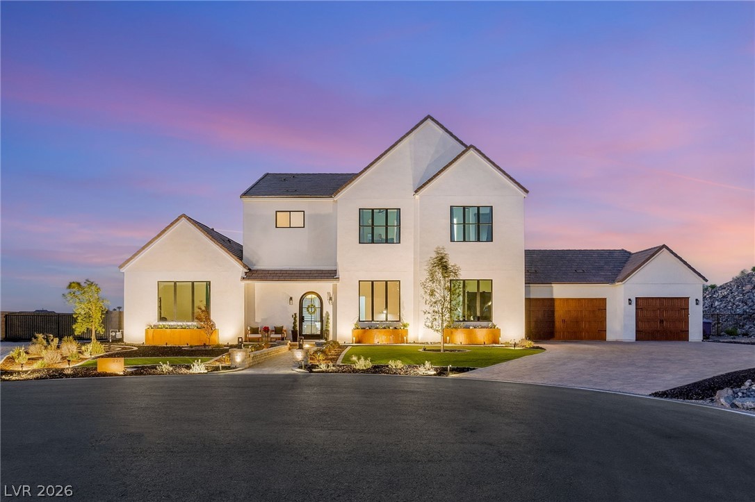 324 Wanda Road Henderson, NV 89002 - Photo 1 of 96 Crisp white stucco and dark-trimmed windows create striking architectural contrast under a twilight sky.