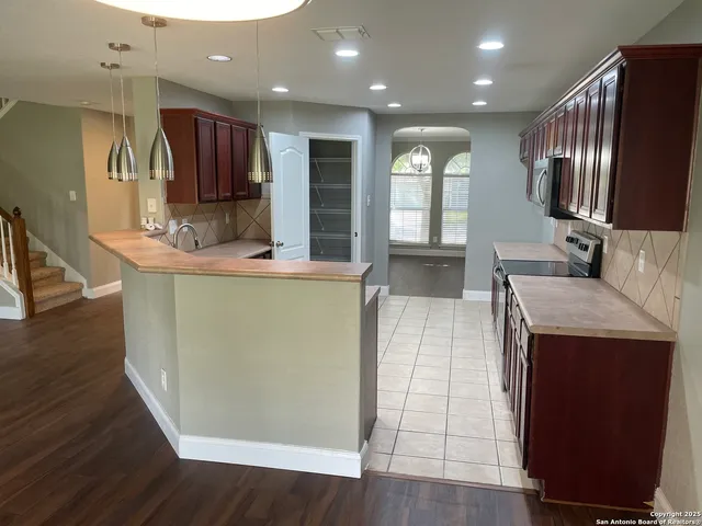 a living room with stainless steel appliances kitchen island granite countertop wooden floor and a view of kitchen