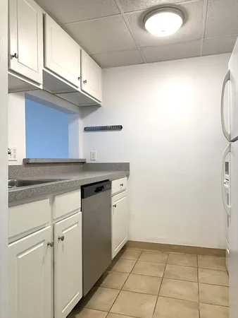 a kitchen with granite countertop a sink a stove and cabinets