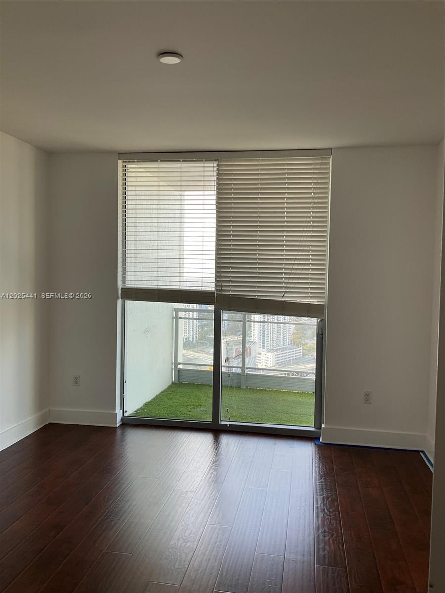 90 Southwest 3rd Street, Unit 3708 Miami, FL 33130 - Photo 10 of 13 an empty room with wooden floor and windows