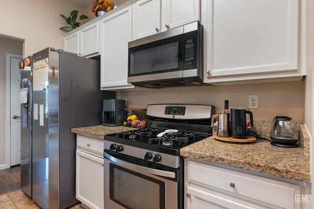 a kitchen with granite countertop cabinets and steel stainless steel appliances