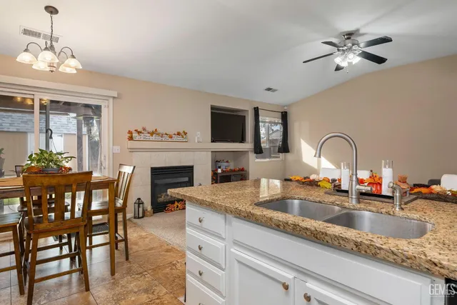 a kitchen with a stove a sink and a dining table with fireplace