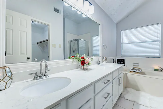 a bathroom with double vanity sinks a mirror and a shower