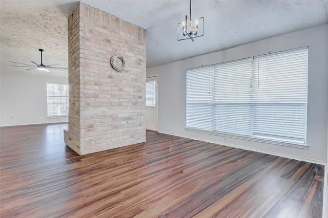 a view of empty room with wooden floor and window
