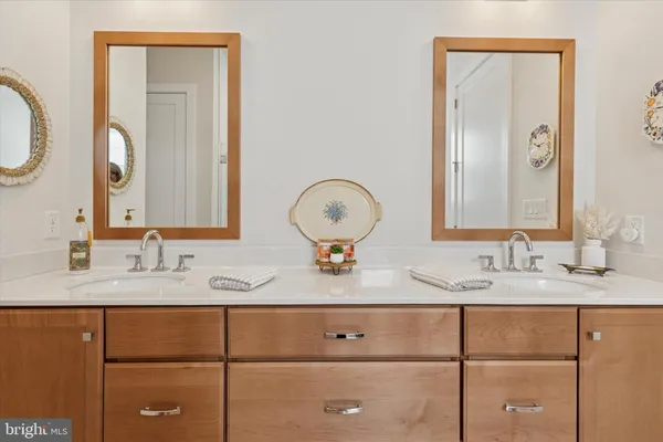 a bathroom with a granite countertop double vanity sink and a mirror