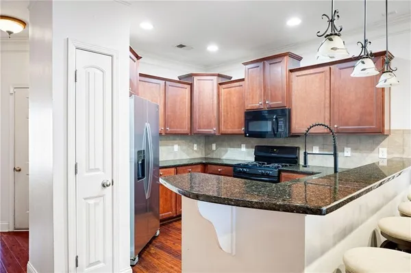 a kitchen with stainless steel appliances granite countertop a sink a stove and a refrigerator