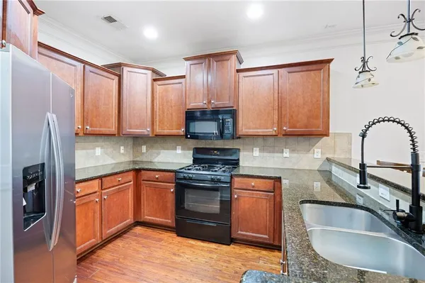 a kitchen with stainless steel appliances granite countertop a sink stove and refrigerator