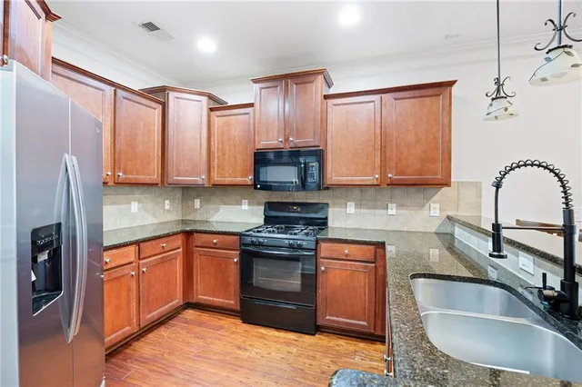 a kitchen with stainless steel appliances granite countertop a sink stove and refrigerator