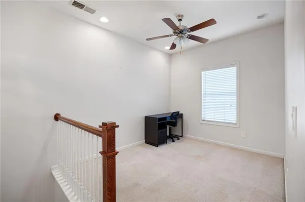 a view of a livingroom with a ceiling fan and wooden floor