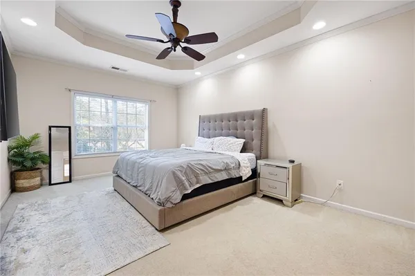 a spacious bedroom with a bed and ceiling fan