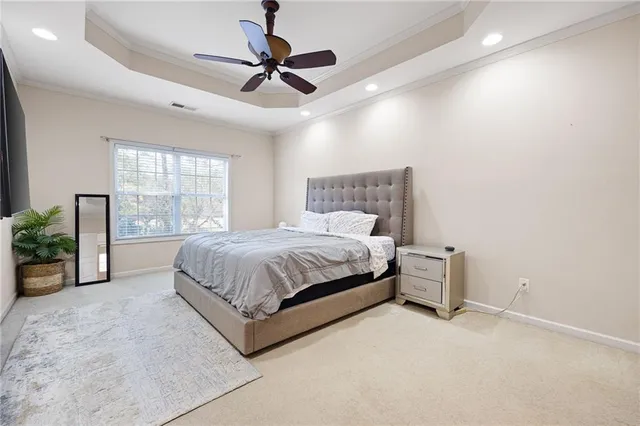a spacious bedroom with a bed and ceiling fan