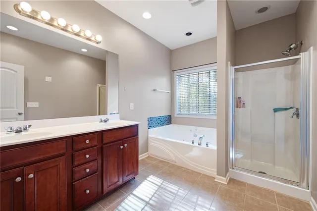 a spacious bathroom with a tub double sink shower and mirror